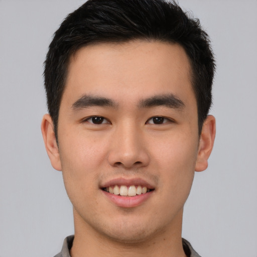 Joyful asian young-adult male with short  brown hair and brown eyes