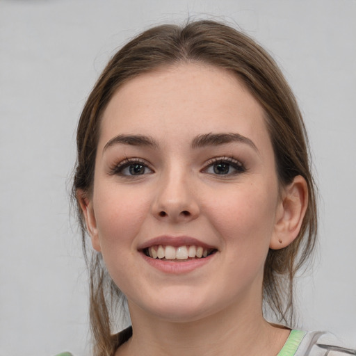 Joyful white young-adult female with medium  brown hair and grey eyes