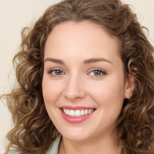 Joyful white young-adult female with long  brown hair and green eyes