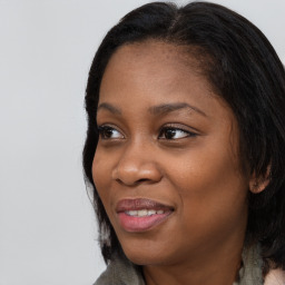 Joyful black young-adult female with long  black hair and brown eyes