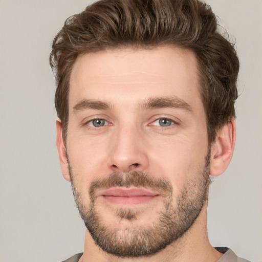 Joyful white young-adult male with short  brown hair and grey eyes