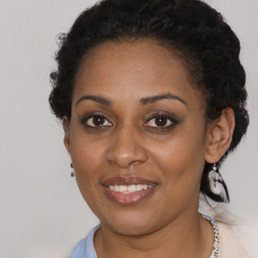 Joyful black young-adult female with short  brown hair and brown eyes