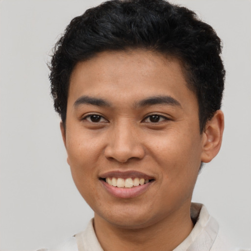 Joyful latino young-adult male with short  brown hair and brown eyes