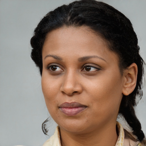 Joyful black young-adult female with long  brown hair and brown eyes