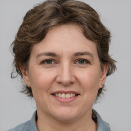 Joyful white adult female with medium  brown hair and grey eyes