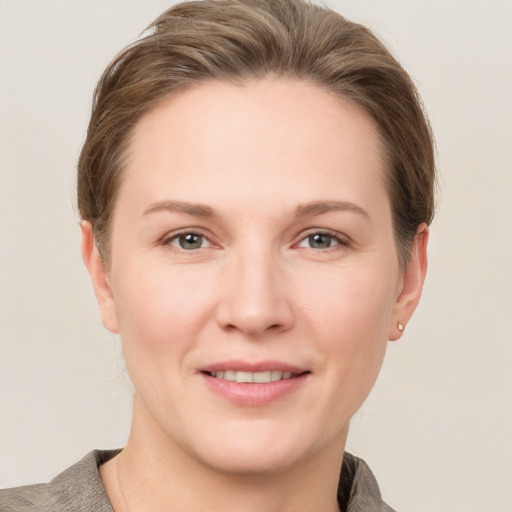 Joyful white young-adult female with short  brown hair and grey eyes