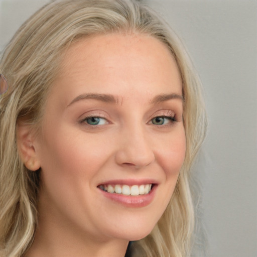 Joyful white young-adult female with long  blond hair and blue eyes