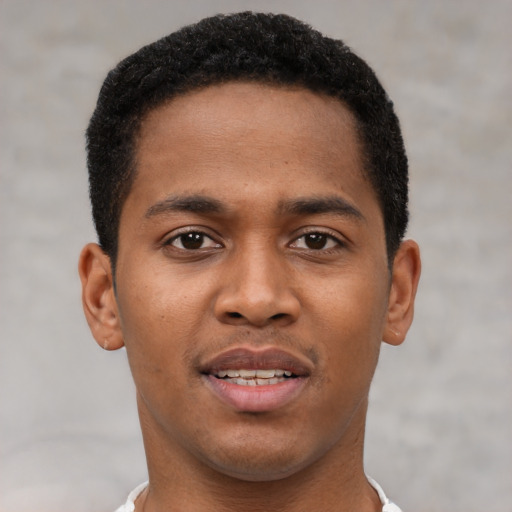 Joyful black young-adult male with short  brown hair and brown eyes