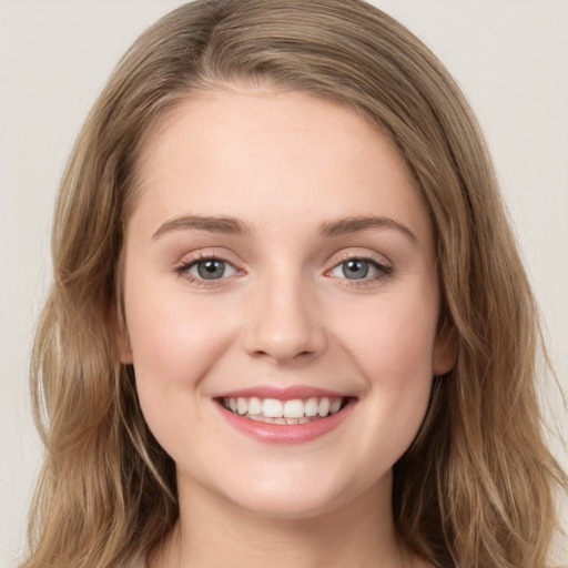 Joyful white young-adult female with long  brown hair and green eyes