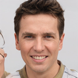 Joyful white adult male with short  brown hair and brown eyes