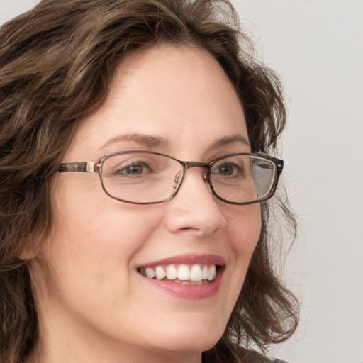 Joyful white adult female with long  brown hair and green eyes