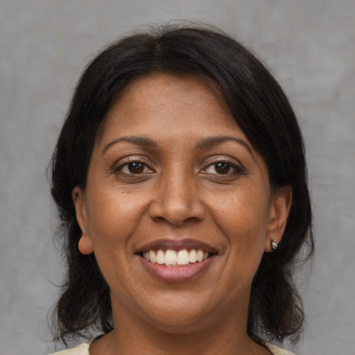 Joyful black adult female with medium  brown hair and brown eyes