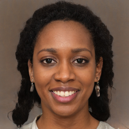 Joyful black young-adult female with long  black hair and brown eyes