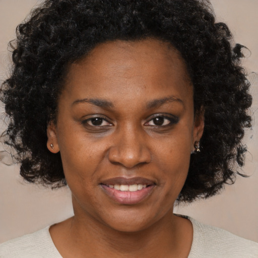 Joyful black young-adult female with medium  brown hair and brown eyes