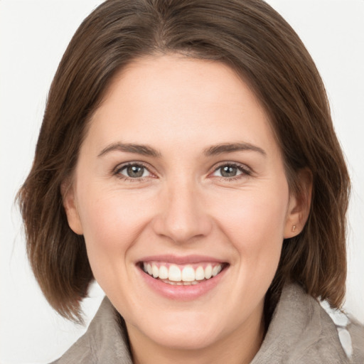 Joyful white young-adult female with medium  brown hair and grey eyes