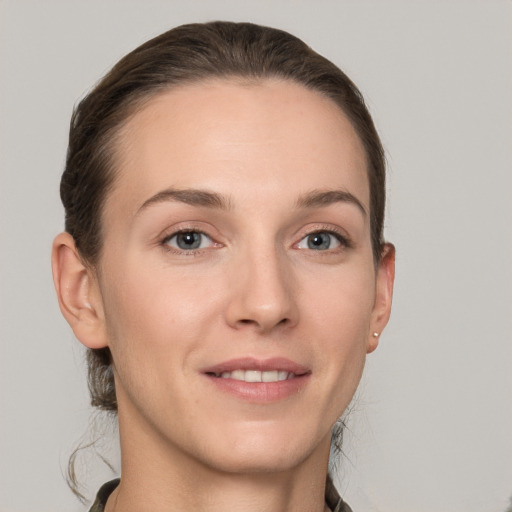 Joyful white young-adult female with short  brown hair and grey eyes