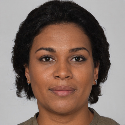 Joyful black adult female with medium  brown hair and brown eyes