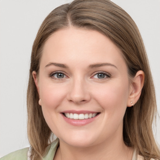 Joyful white young-adult female with long  brown hair and grey eyes