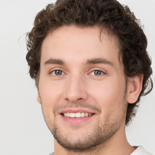 Joyful white young-adult male with short  brown hair and green eyes