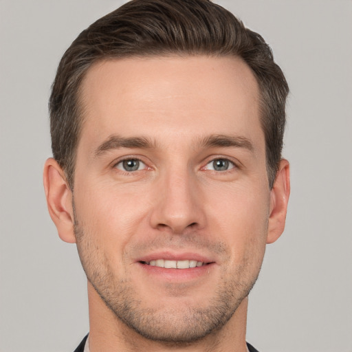 Joyful white young-adult male with short  brown hair and grey eyes