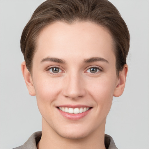 Joyful white young-adult female with short  brown hair and grey eyes