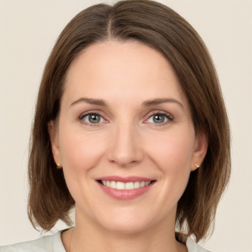 Joyful white young-adult female with medium  brown hair and green eyes