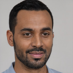 Joyful black young-adult male with short  black hair and brown eyes