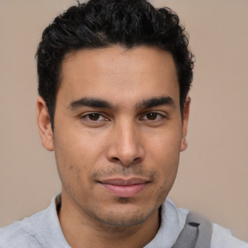 Joyful latino young-adult male with short  brown hair and brown eyes