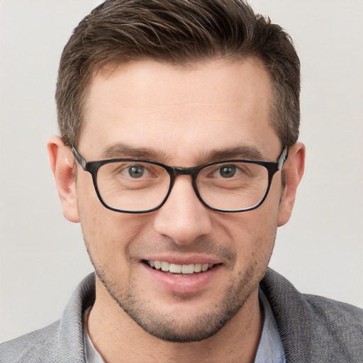 Joyful white young-adult male with short  brown hair and blue eyes