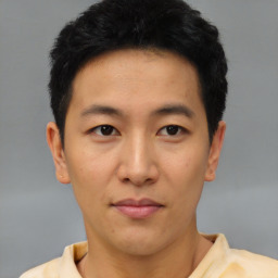 Joyful asian young-adult male with short  brown hair and brown eyes