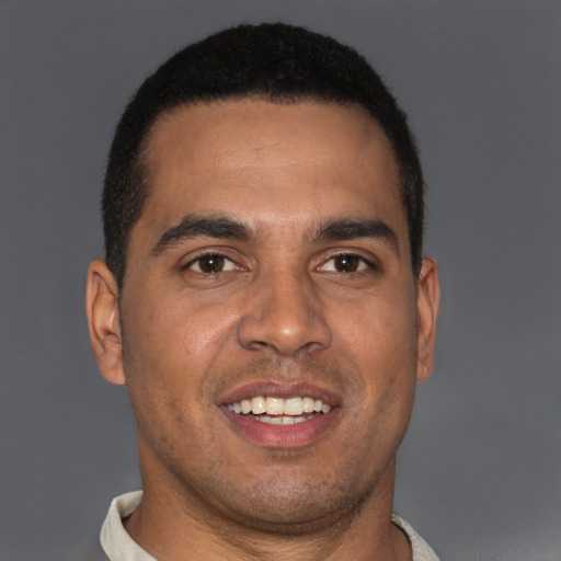 Joyful latino young-adult male with short  brown hair and brown eyes