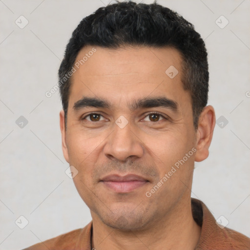 Joyful latino young-adult male with short  black hair and brown eyes