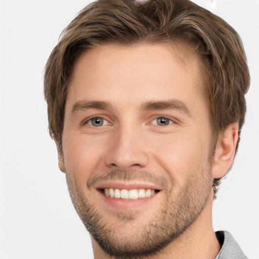 Joyful white young-adult male with short  brown hair and grey eyes