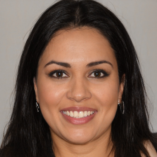Joyful latino young-adult female with long  brown hair and brown eyes