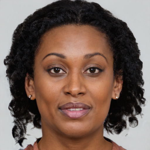 Joyful black adult female with medium  brown hair and brown eyes
