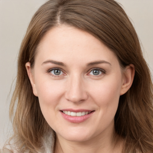 Joyful white young-adult female with long  brown hair and grey eyes