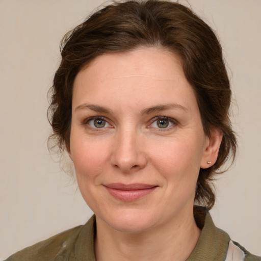 Joyful white young-adult female with medium  brown hair and green eyes