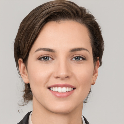 Joyful white young-adult female with medium  brown hair and grey eyes