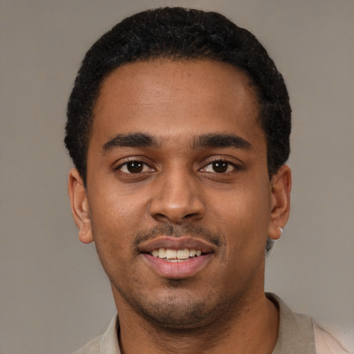 Joyful black young-adult male with short  black hair and brown eyes