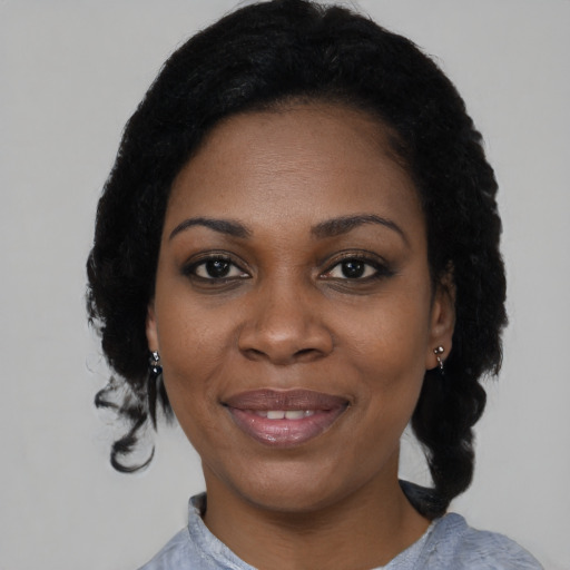 Joyful black adult female with medium  black hair and brown eyes