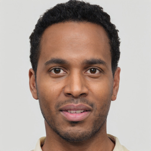 Joyful black young-adult male with short  black hair and brown eyes