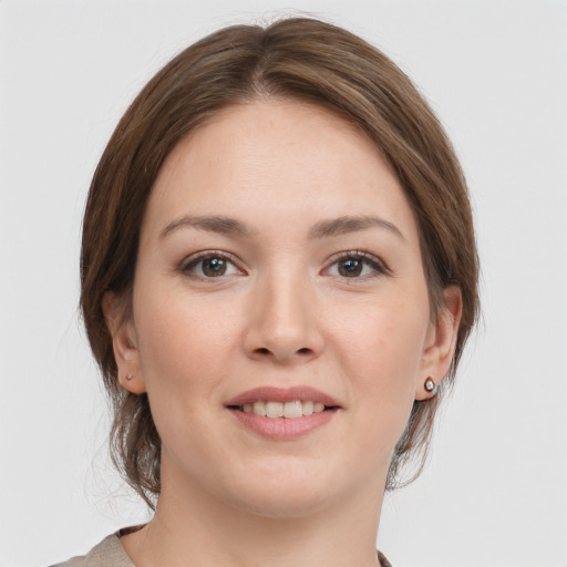 Joyful white young-adult female with medium  brown hair and grey eyes