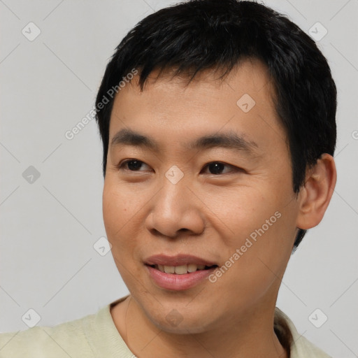 Joyful asian young-adult male with short  black hair and brown eyes