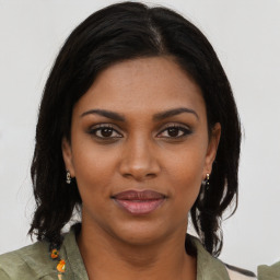 Joyful black young-adult female with medium  brown hair and brown eyes