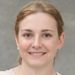 Joyful white young-adult female with medium  brown hair and grey eyes