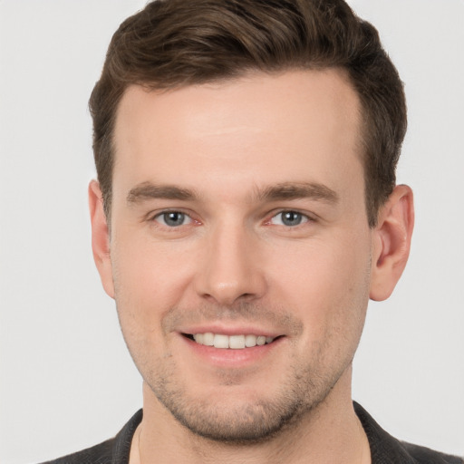 Joyful white young-adult male with short  brown hair and grey eyes