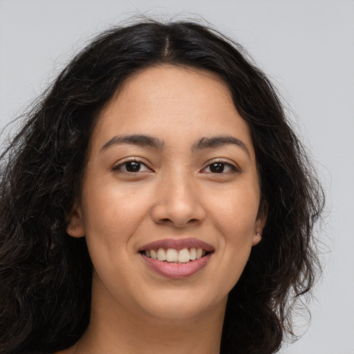 Joyful latino young-adult female with long  brown hair and brown eyes