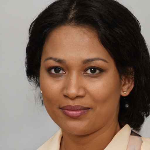 Joyful black adult female with medium  brown hair and brown eyes