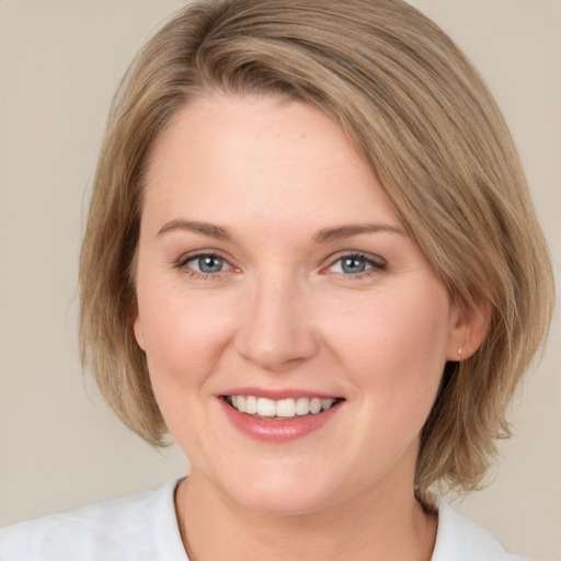 Joyful white young-adult female with medium  brown hair and blue eyes