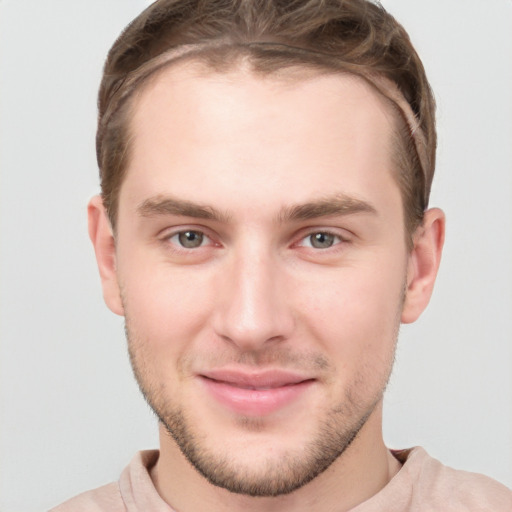 Joyful white young-adult male with short  brown hair and grey eyes